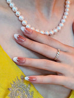 La Perle press-on nails — styled lifestyle shot with pearl necklace